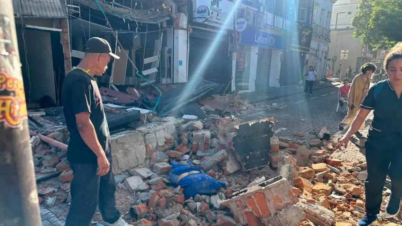 Residents beside a damaged street and buildings after the August 10, 2026 earthquake
